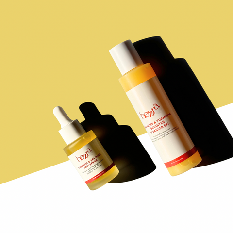 two bottles of face wash and face serum made with turmeric that are next to each other