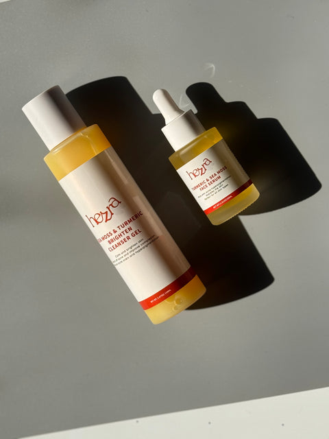 two bottles of face wash and face serum made with turmeric that are next to each other